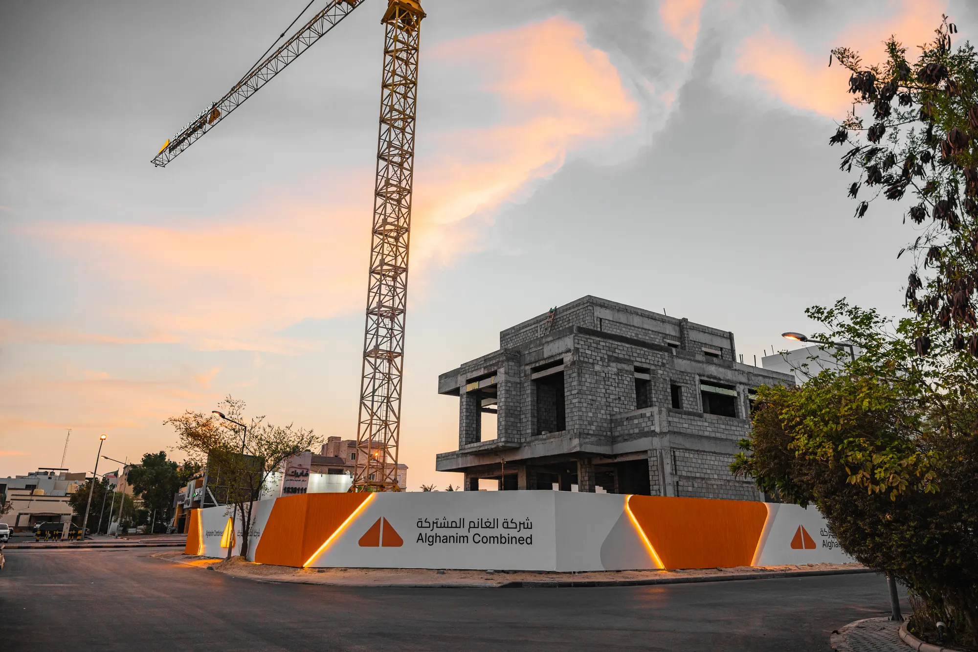 Alghanim Combined site hoarding and tower crane at sunset in Kuwait